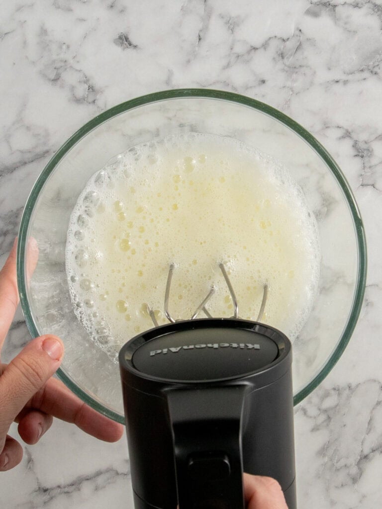 Whisking the egg whites until frothy