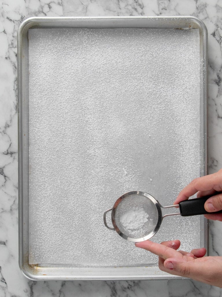 Dusting the baking tray with powdered sugar