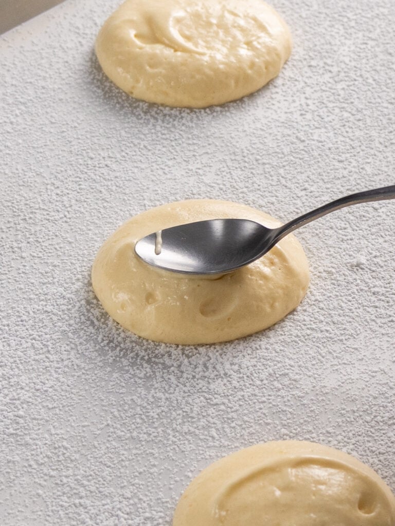 Using a spoon to shape the batter into rounder shapes