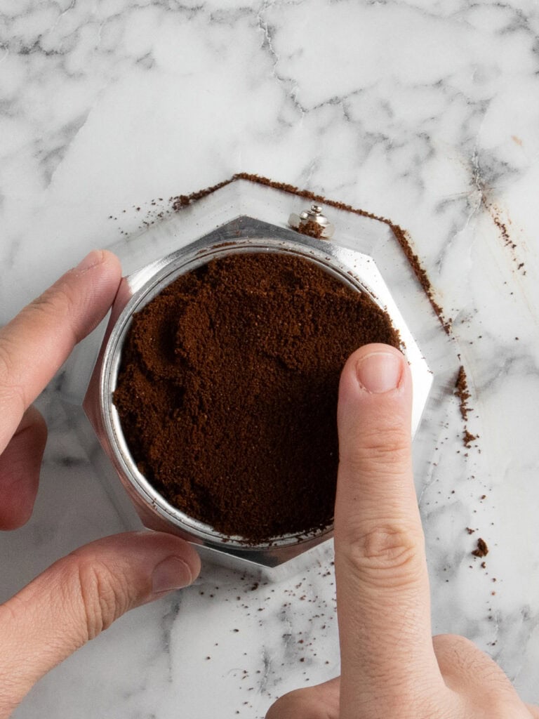 Add the ground coffee to the cafetera