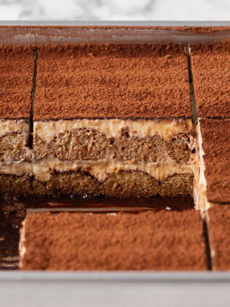 Extreme close up of an Italian layered coffee and cream dessert sitting in the tin showing the sliced up layers