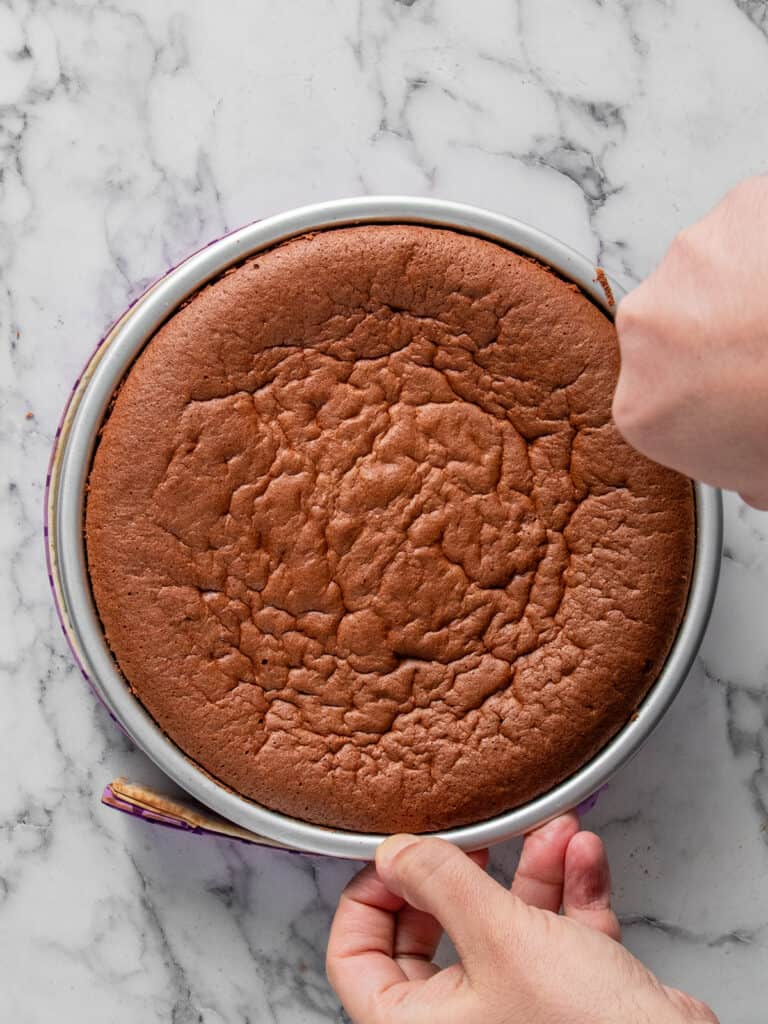 Running a knife around the cake tin to loosen the cake after its cooled a little