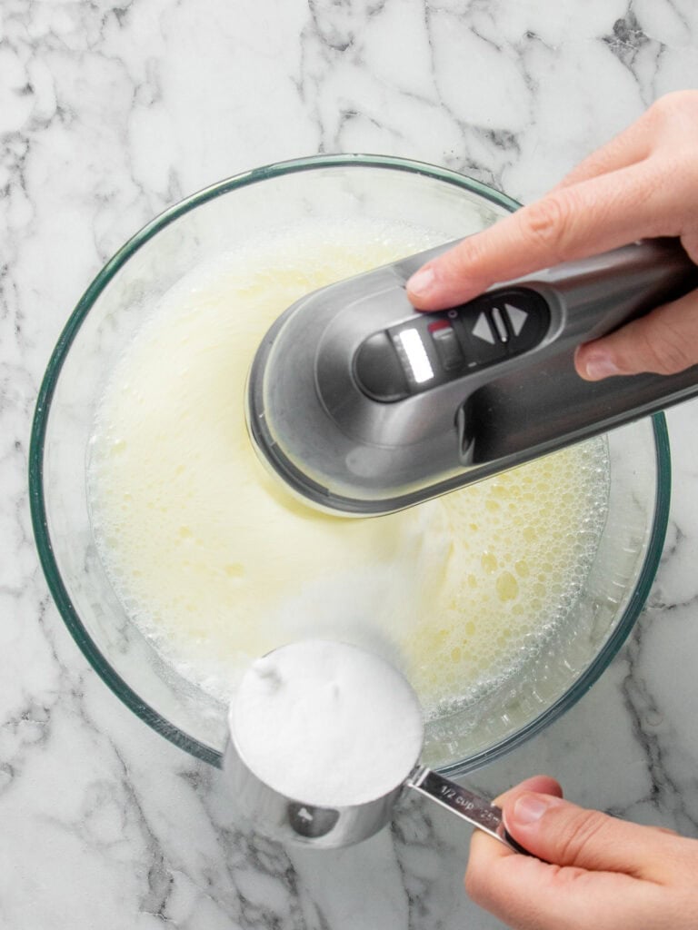 Whisking the egg whites and slowly adding sugar