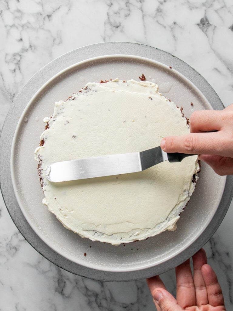 Adding Chantilly cream to the first layer of cake