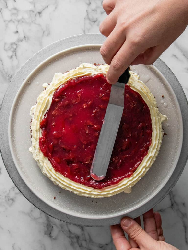 Adding a layer of cooled cherry sauce on top of the cake layer