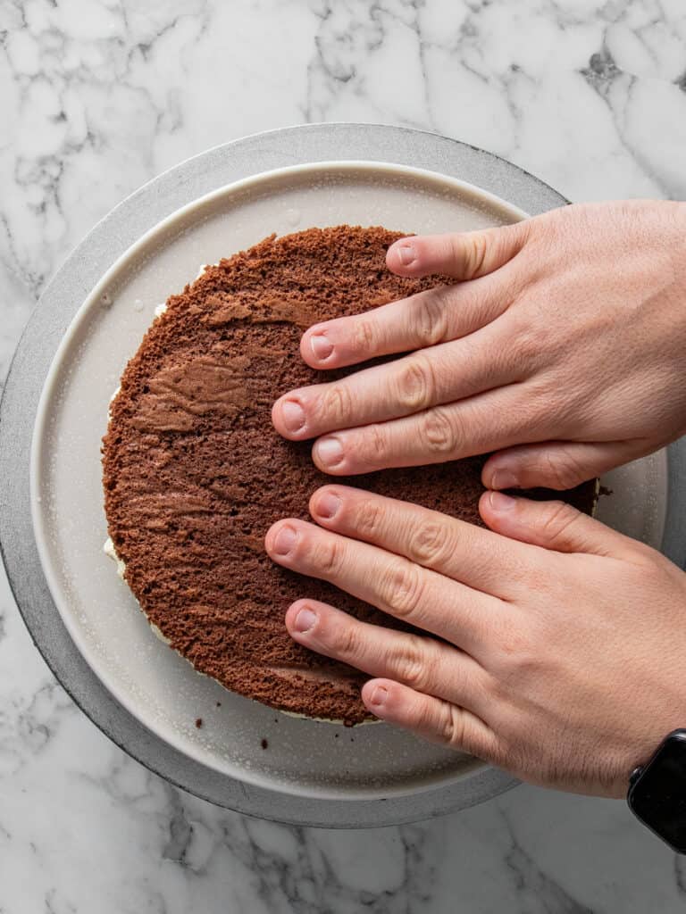 Adding the next layer of cake and repeating the layering process