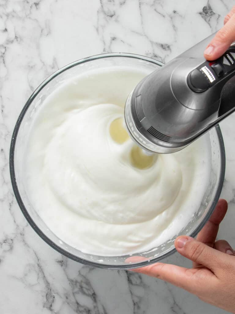 Whisking the egg whites to make the meringue