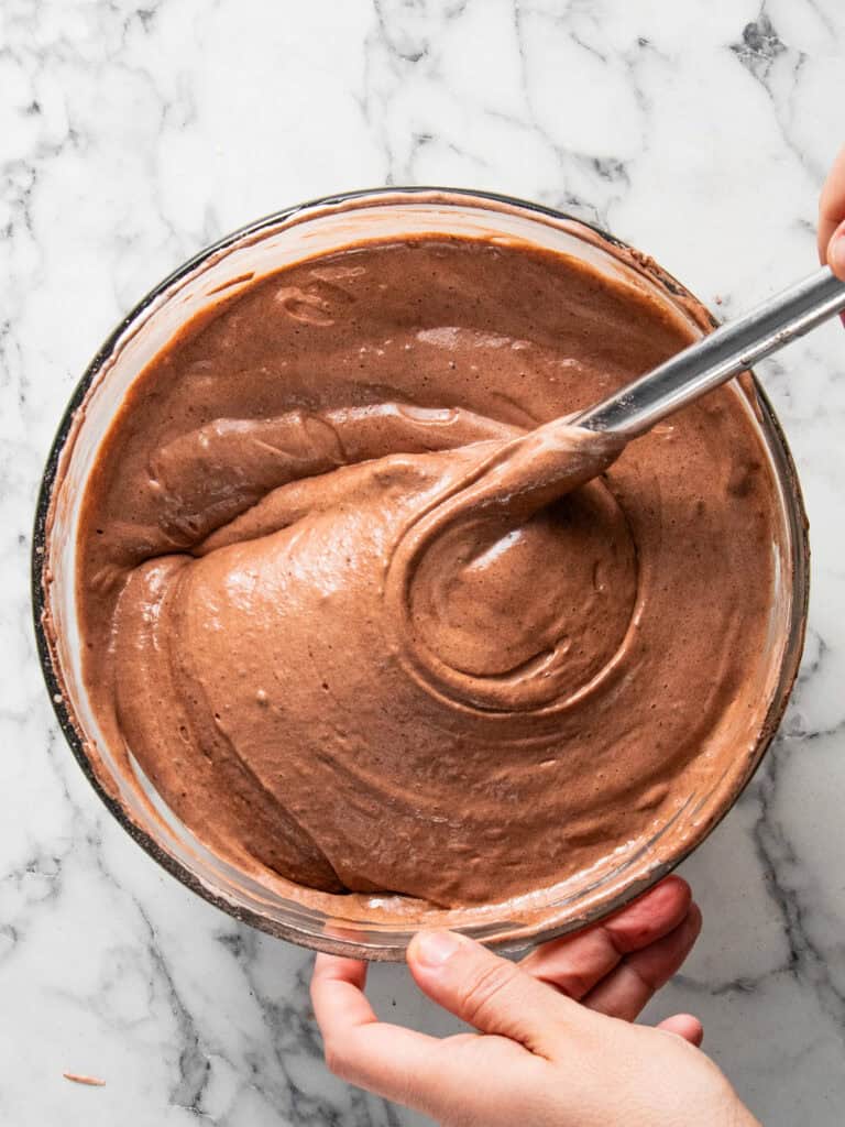Adding the meringue to the batter to finish it
