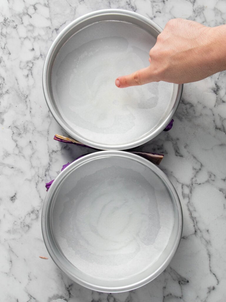 Greasing the bottom of the cake tins and lining with baking paper