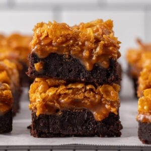 Square image of a stack of crispy caramel topped brownie bars