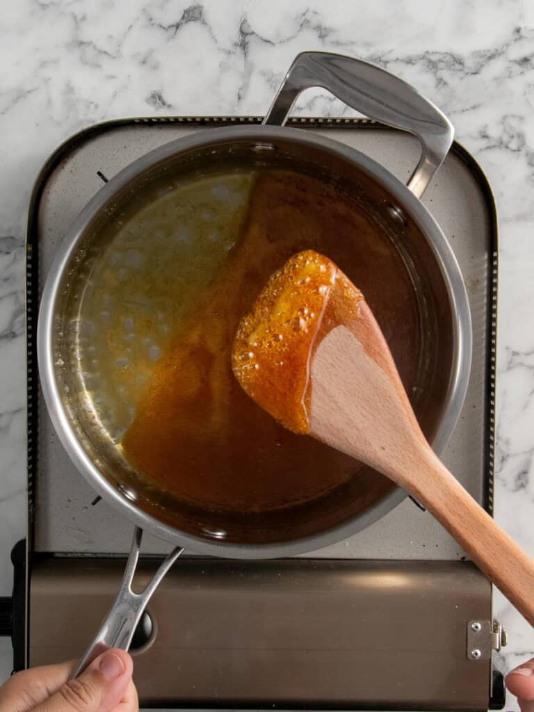 Toffee on a wooden spoon to show how golden it is