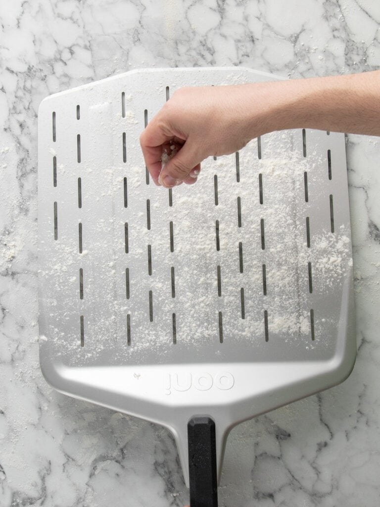 Sprinkling the pizza peel with flour