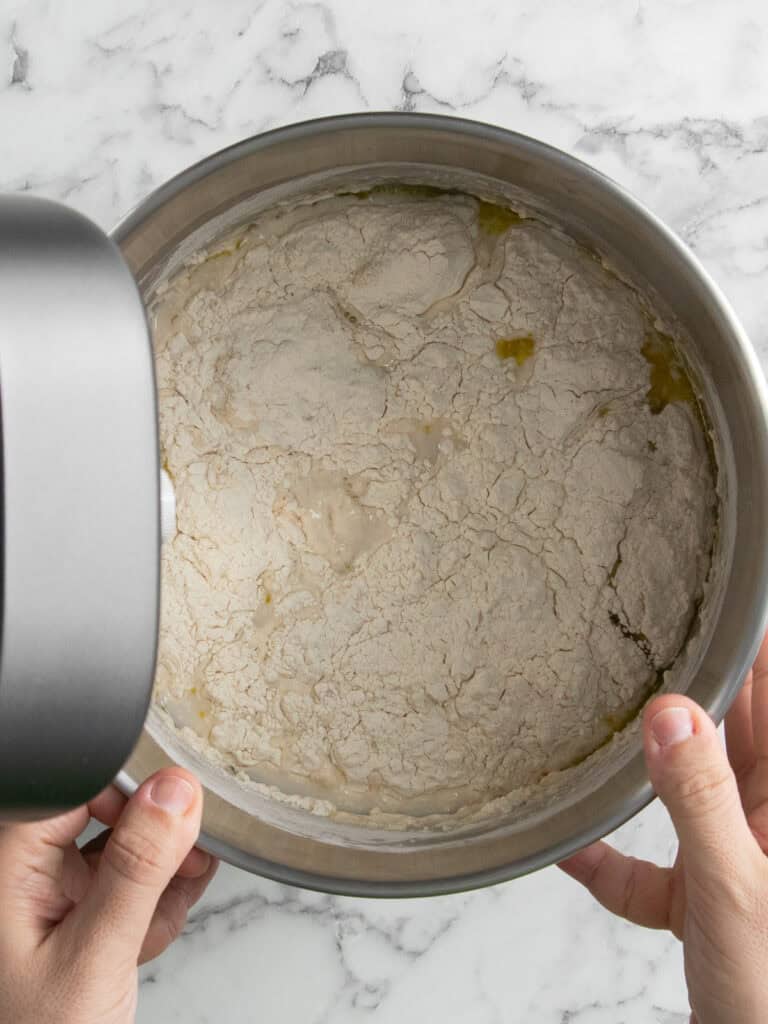 Adding all of the dough ingredients into a stand mixer to knead them