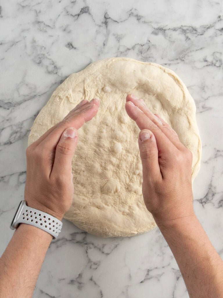Curving hands to get ready to stretch the dough
