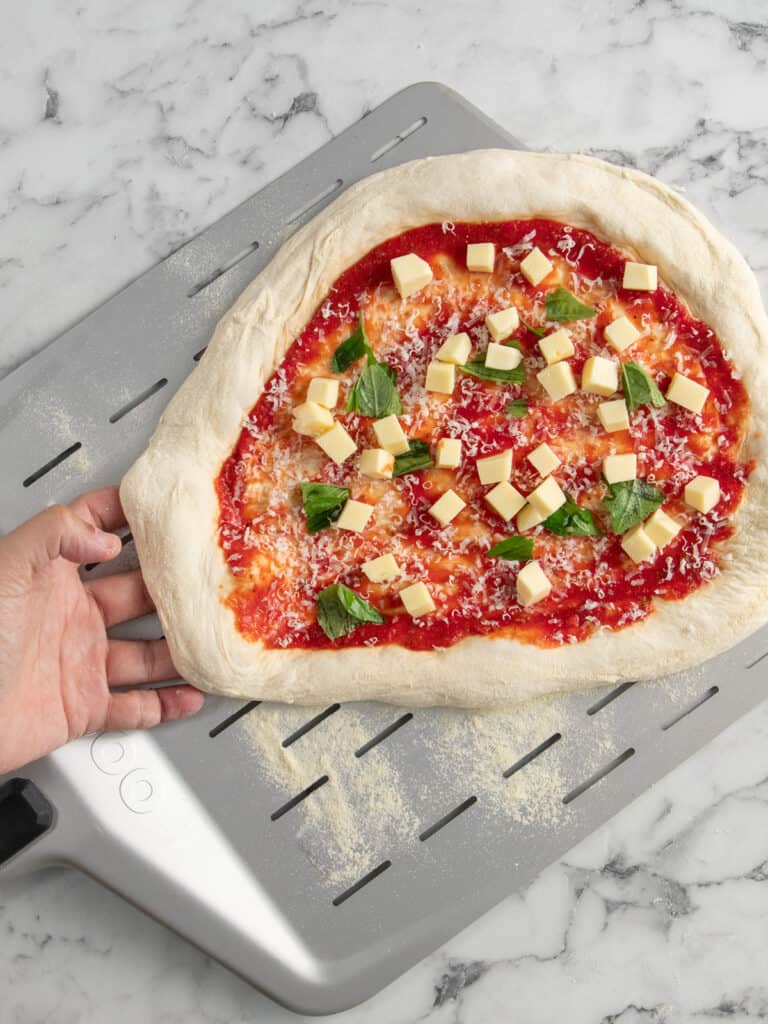 Sliding the pizza peel under the decorated pizza