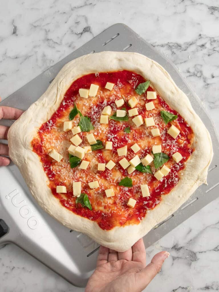 Shaping the pizza back into a round shape