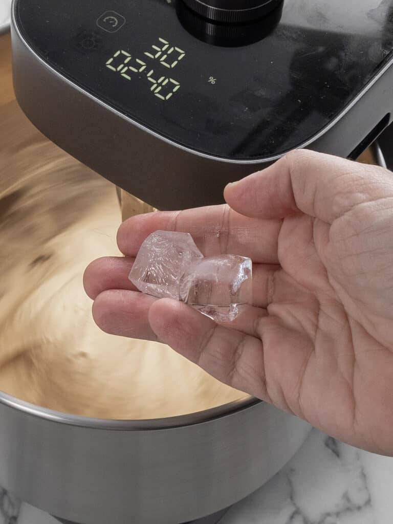 Adding two ice cubes to the dough to keep temperature down