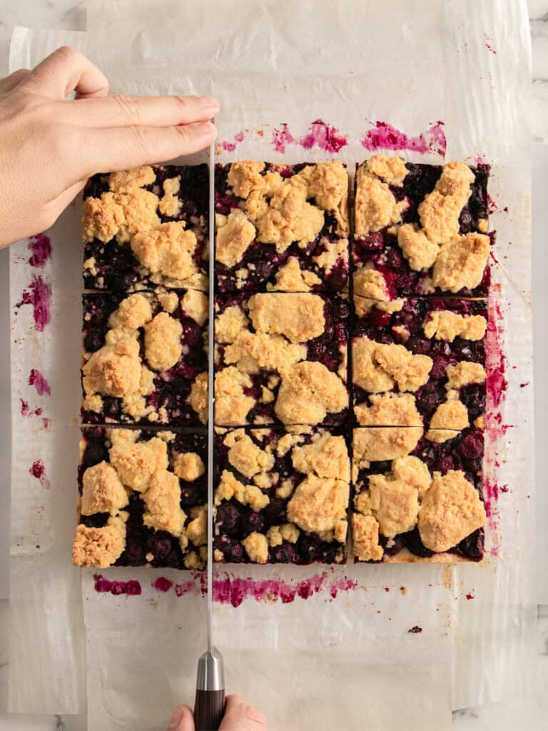 Slice of berry crumble dessert with crumb topping and berry filling.